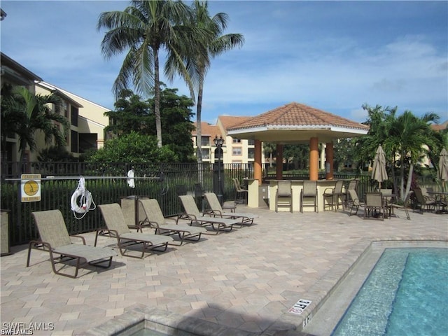 view of pool featuring a patio, a gazebo, and an outdoor bar