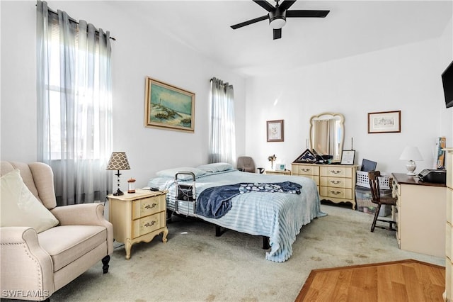 carpeted bedroom with multiple windows and ceiling fan