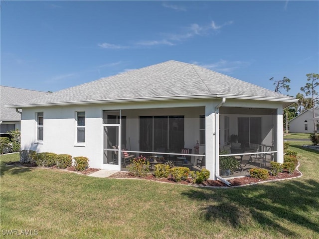 rear view of property featuring a sunroom and a lawn