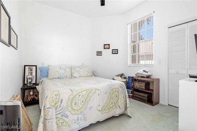 carpeted bedroom featuring ceiling fan and a closet