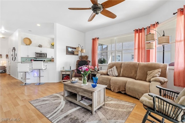 living room featuring ceiling fan and light hardwood / wood-style flooring