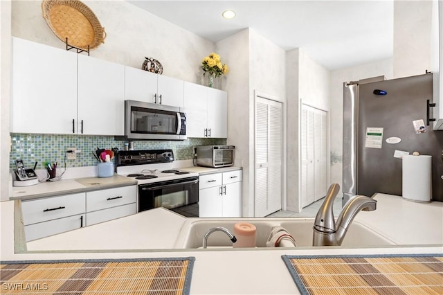 kitchen with white cabinetry, stainless steel appliances, and decorative backsplash