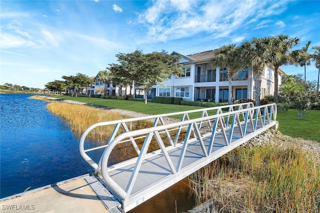 dock area featuring a water view and a lawn