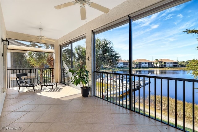 sunroom / solarium with a water view and ceiling fan