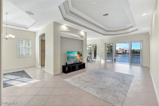 living room with crown molding, a raised ceiling, a healthy amount of sunlight, and light tile patterned flooring