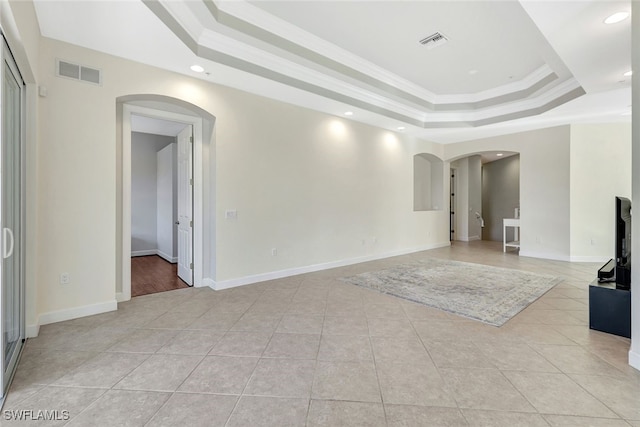 unfurnished living room featuring crown molding, a raised ceiling, and light tile patterned flooring