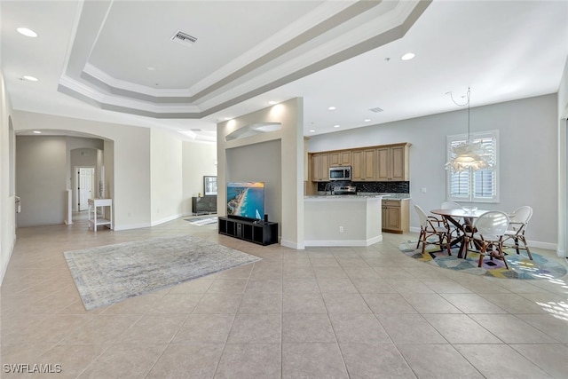 interior space with light tile patterned flooring, crown molding, and a tray ceiling