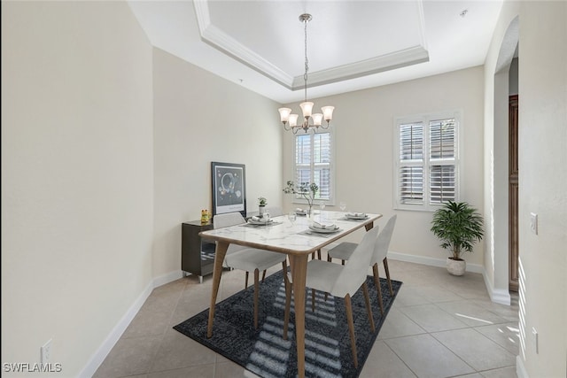 dining space featuring light tile patterned floors, ornamental molding, a raised ceiling, and baseboards