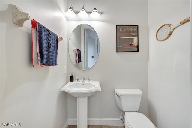 bathroom with toilet and baseboards