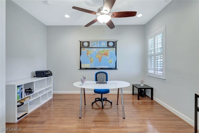 office space with a ceiling fan, recessed lighting, light wood-style flooring, and baseboards