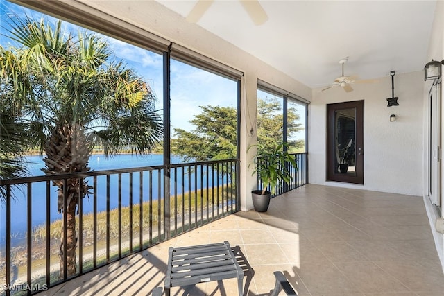 sunroom with a water view and ceiling fan