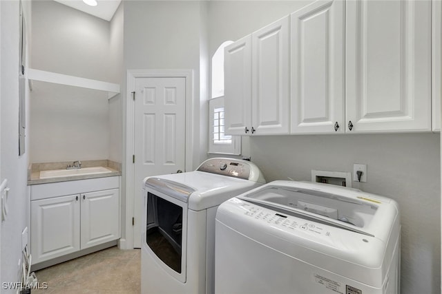 washroom featuring cabinets, sink, light tile patterned floors, and washer and clothes dryer