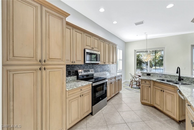 kitchen with decorative light fixtures, sink, light tile patterned floors, stainless steel appliances, and light stone countertops