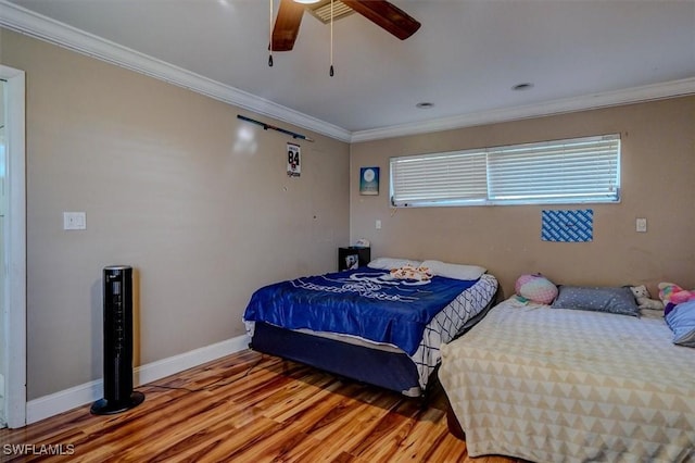 bedroom with crown molding, wood-type flooring, and ceiling fan