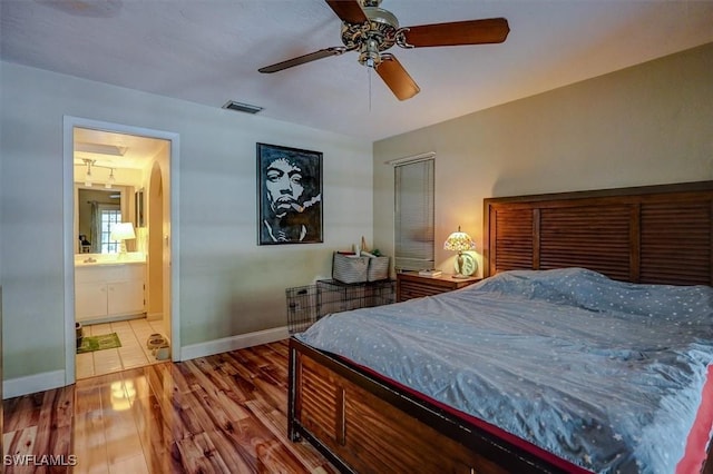 bedroom featuring ceiling fan, wood-type flooring, and ensuite bath