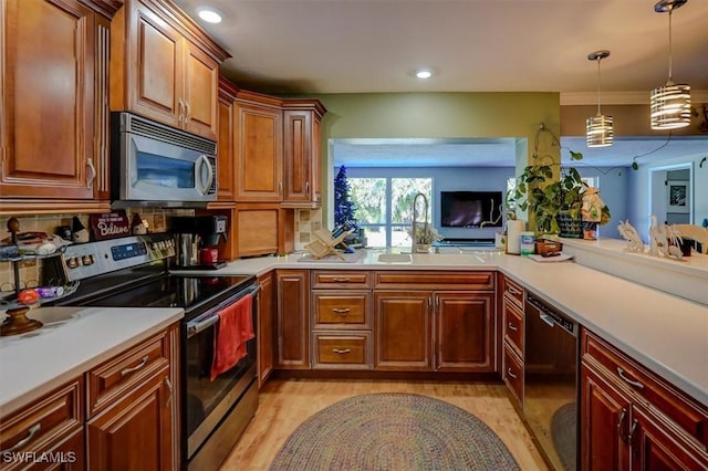 kitchen with pendant lighting, sink, light hardwood / wood-style flooring, stainless steel appliances, and decorative backsplash