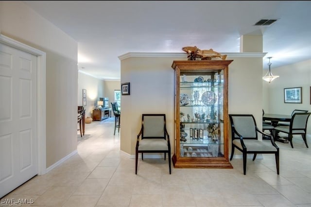 sitting room featuring crown molding and light tile patterned flooring