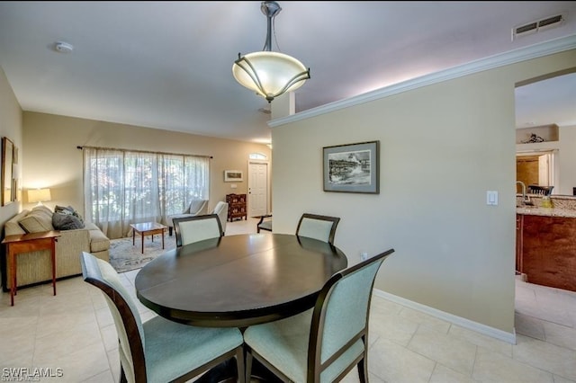 tiled dining space featuring ornamental molding