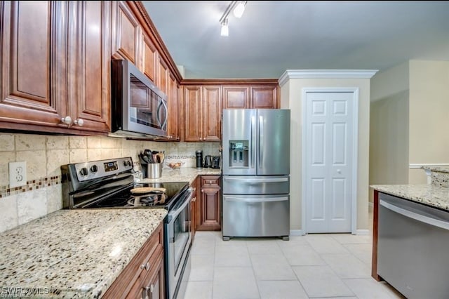 kitchen featuring light stone counters, light tile patterned floors, tasteful backsplash, and stainless steel appliances