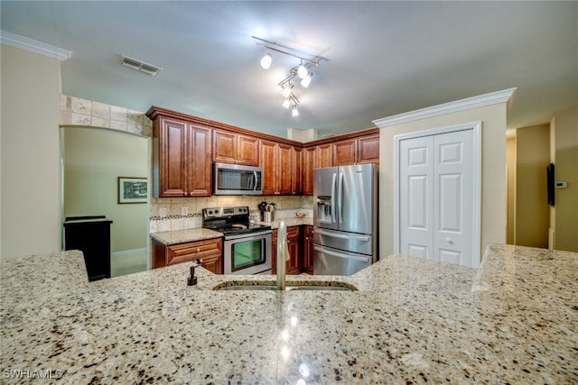 kitchen featuring appliances with stainless steel finishes, sink, decorative backsplash, ornamental molding, and light stone countertops