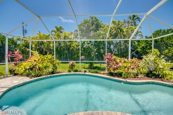 view of pool with glass enclosure