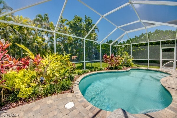 view of swimming pool with a patio and glass enclosure