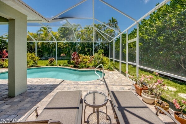 view of swimming pool with glass enclosure and a patio area