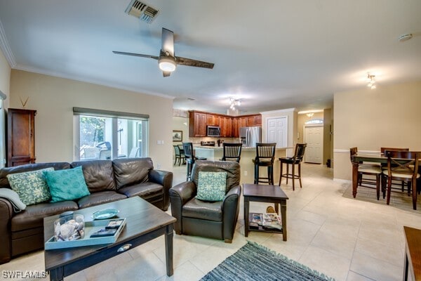 tiled living room featuring ceiling fan and ornamental molding