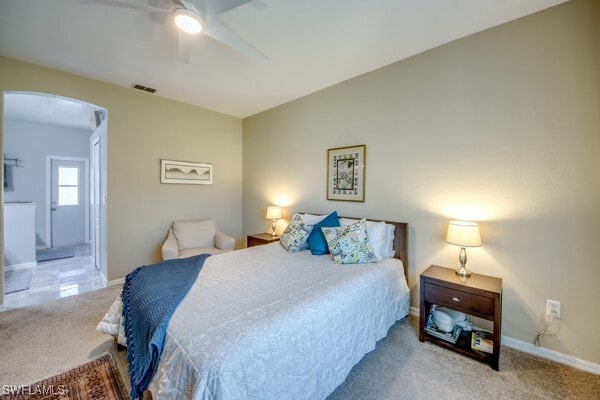 bedroom with light carpet, ceiling fan, and ensuite bathroom