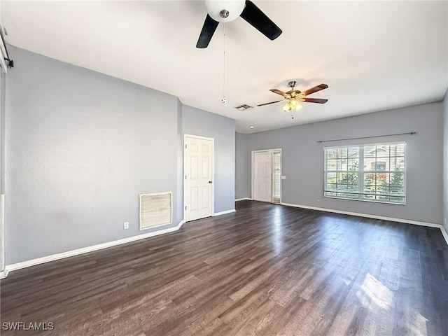 empty room with ceiling fan and dark hardwood / wood-style flooring