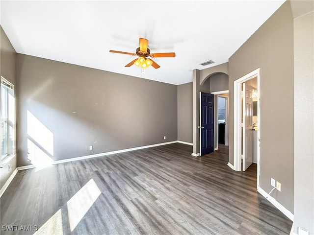 empty room with ceiling fan and dark hardwood / wood-style flooring