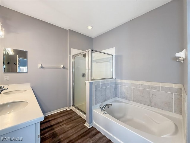 bathroom with hardwood / wood-style flooring, vanity, and separate shower and tub