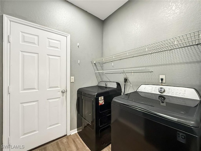 washroom featuring wood-type flooring and washing machine and clothes dryer