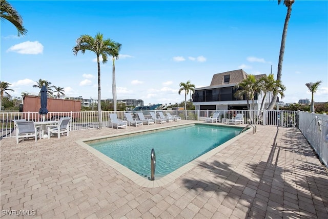 view of swimming pool featuring a sunroom and a patio area