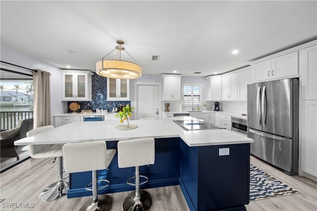 kitchen featuring pendant lighting, sink, stainless steel appliances, and a center island