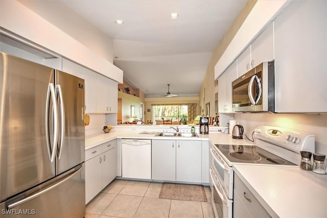 kitchen with light tile patterned floors, appliances with stainless steel finishes, sink, and white cabinets