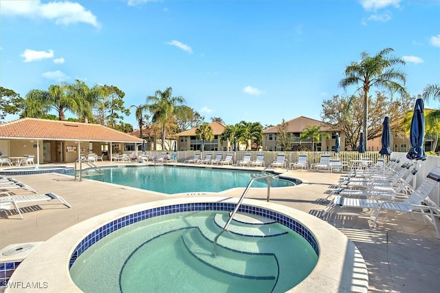 view of pool with a hot tub and a patio area