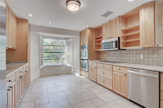 kitchen featuring light stone countertops, decorative backsplash, stainless steel appliances, and light brown cabinets