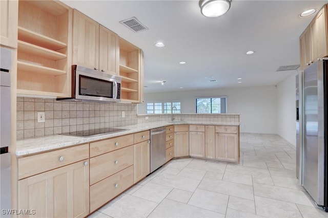 kitchen with stainless steel appliances, light brown cabinetry, and kitchen peninsula