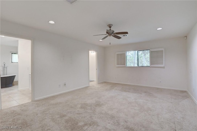 carpeted spare room with ceiling fan