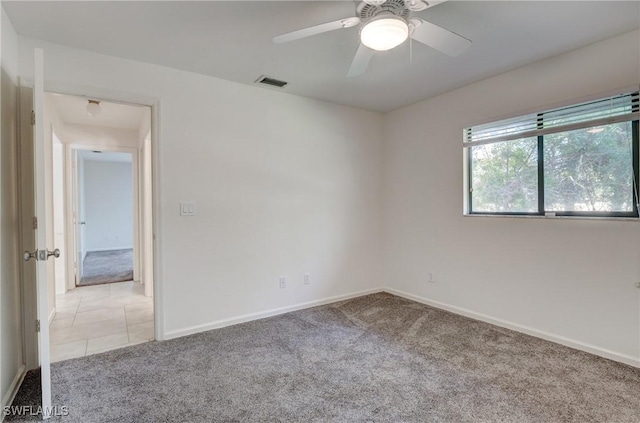 carpeted spare room with ceiling fan