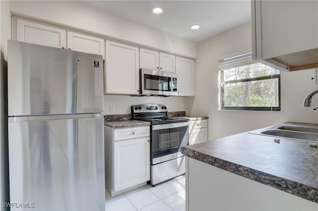 kitchen featuring light tile patterned floors, stainless steel appliances, sink, and white cabinets