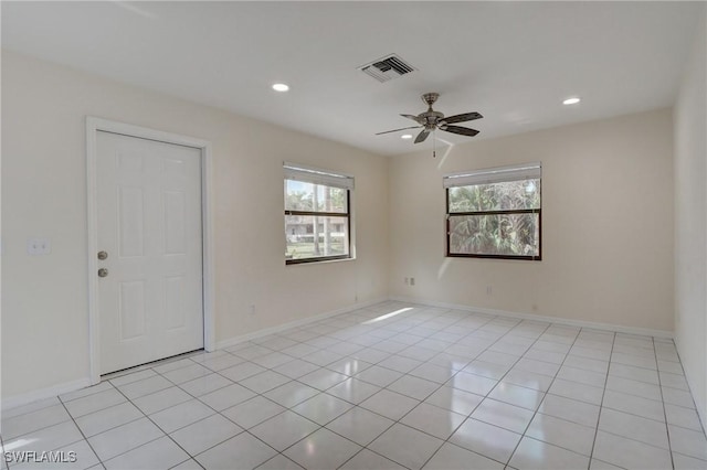 tiled spare room featuring ceiling fan