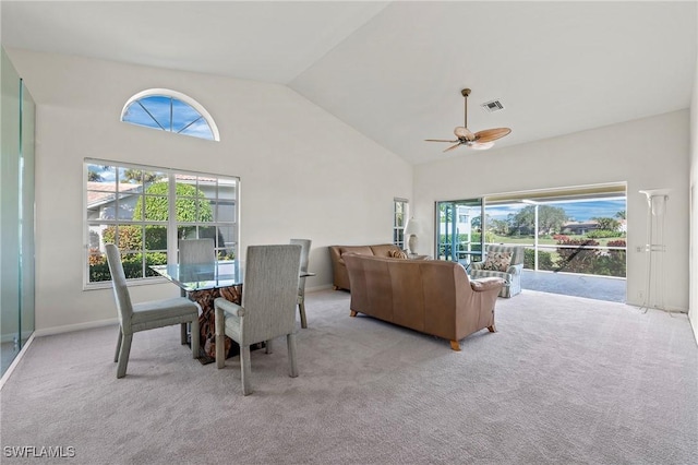 carpeted dining room featuring high vaulted ceiling and ceiling fan