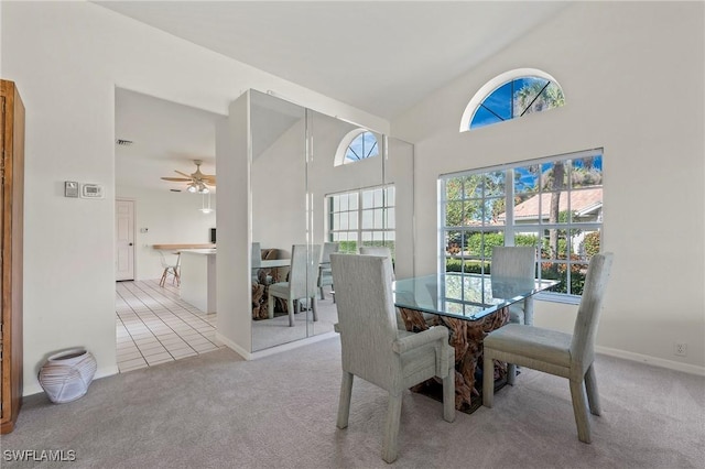 carpeted dining area with high vaulted ceiling