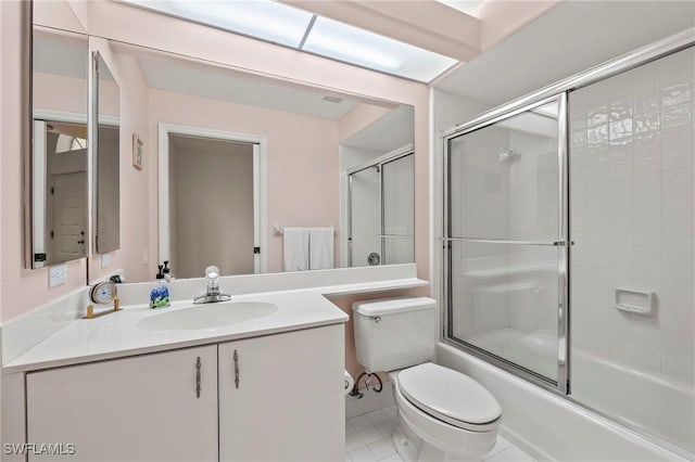 full bathroom featuring vanity, combined bath / shower with glass door, tile patterned floors, and toilet