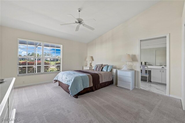 bedroom featuring ensuite bathroom, high vaulted ceiling, light carpet, and ceiling fan