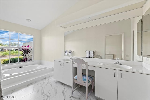 bathroom featuring lofted ceiling, vanity, and a tub