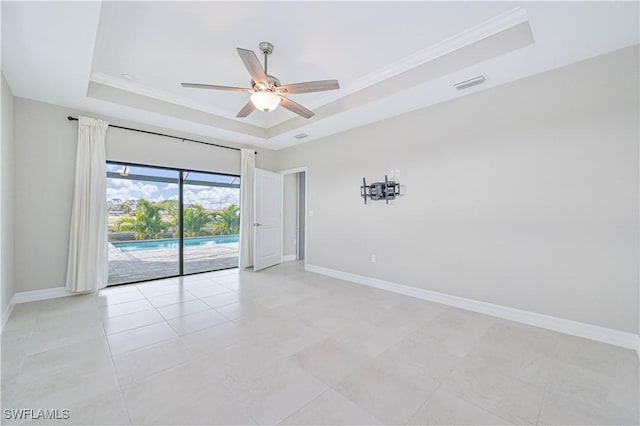 spare room with crown molding, a tray ceiling, and ceiling fan