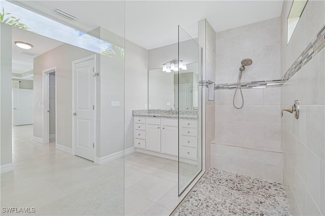 bathroom with vanity and a tile shower